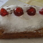 A loaf cake with glace cherries on top